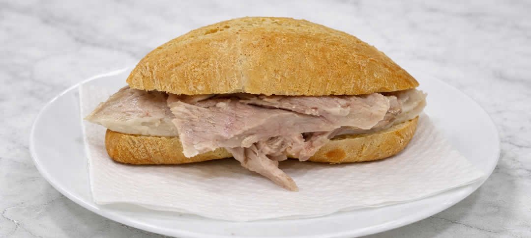 bocadillo de pata en plato blanco sobre mesa de marmol