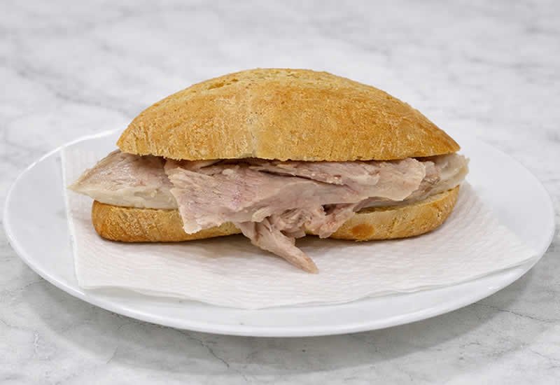 bocadillo de pata en plato blanco sobre mesa de marmol